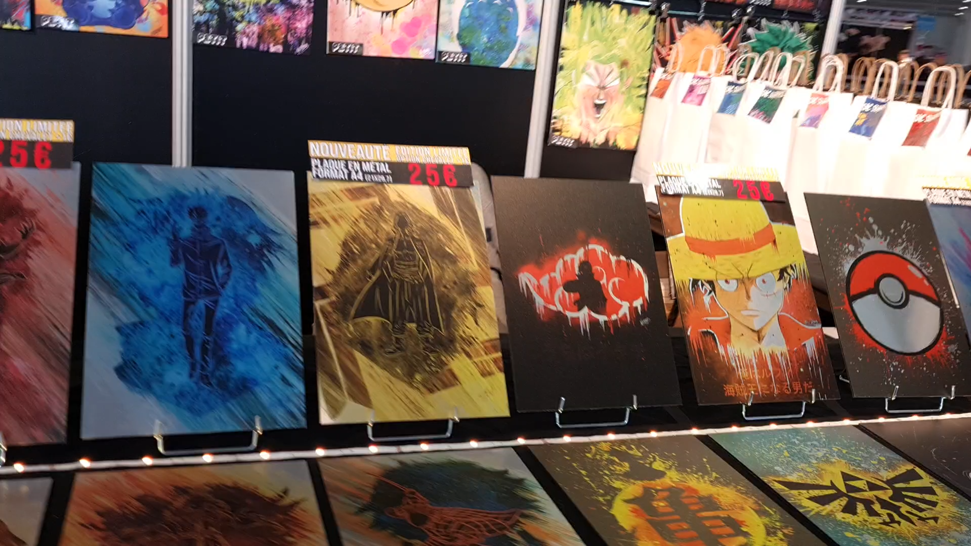 Stand de la Made in Asia exposant des plaques métalliques décoratives inspirées de la pop culture geek, représentant notamment Luffy de One Piece, une Pokéball de Pokémon, le logo Akatsuki de Naruto et des visuels de Dragon Ball et Zelda.